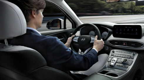 The new i30 Hatchback driving towards a bridge.