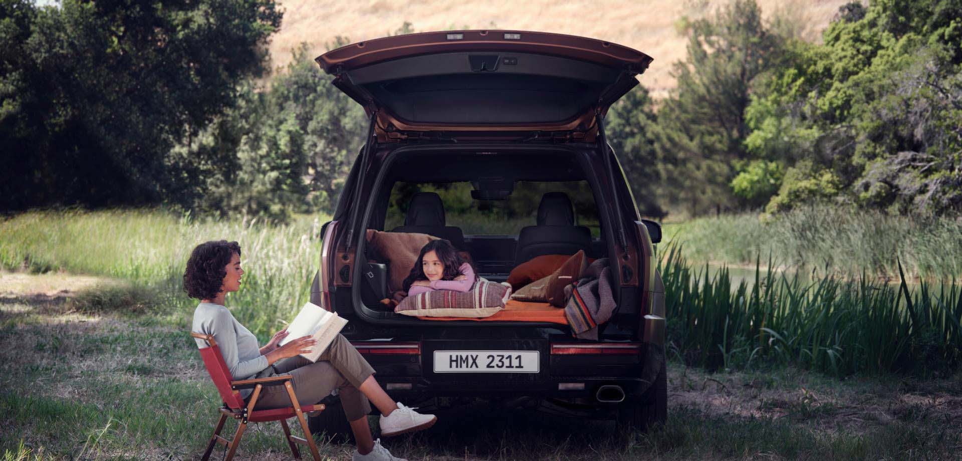 Two women are unwinding, one inside and the other outside the trunk of a SANTA FE