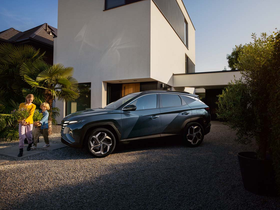 фото нового TUCSON на фоні будинку з дітьми